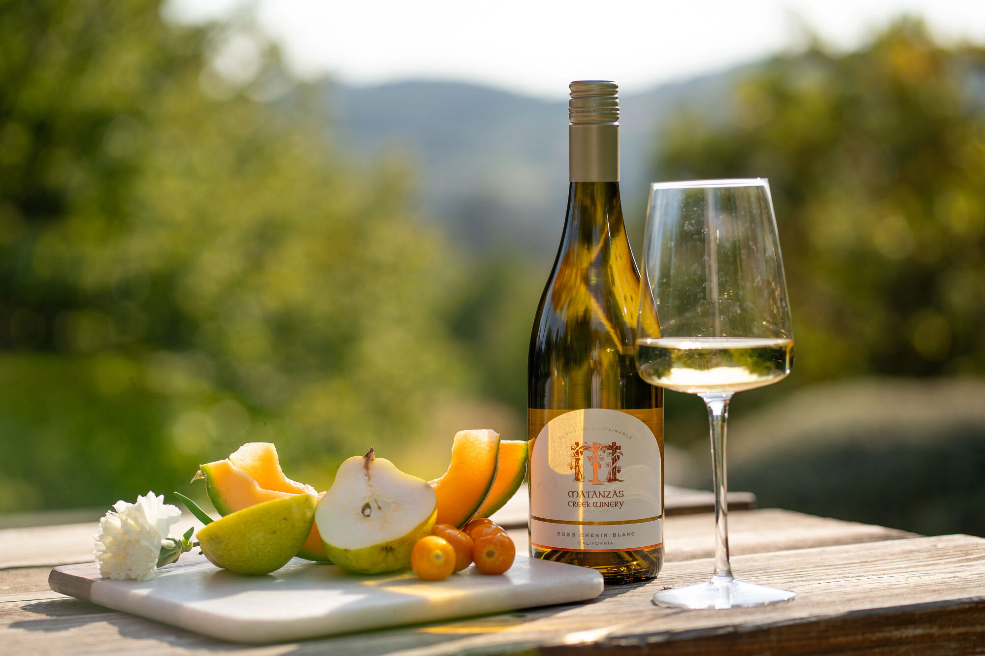 Matanzas Creek Wine bottle and glass of wine with fruit on a cutting board