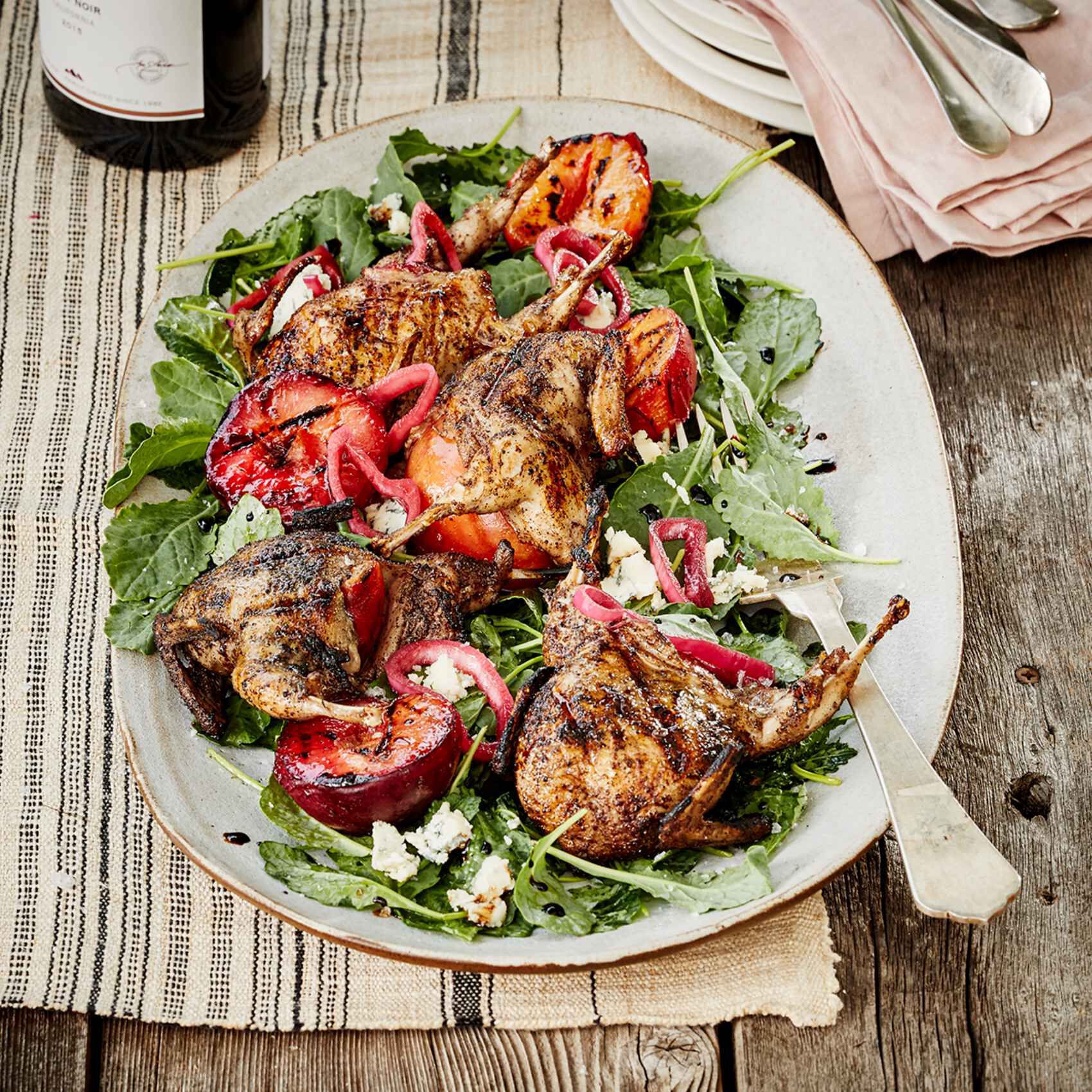 A plate of Grilled Quail with Plums & Hibiscus Pickled Shallots